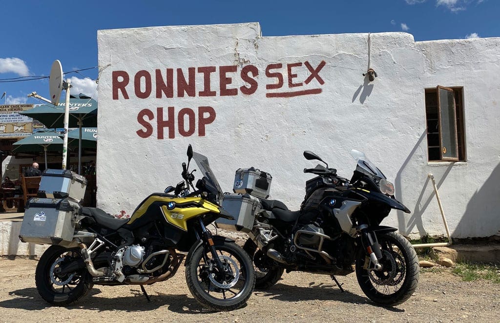 Two bike parked out side the front of an adult shop.