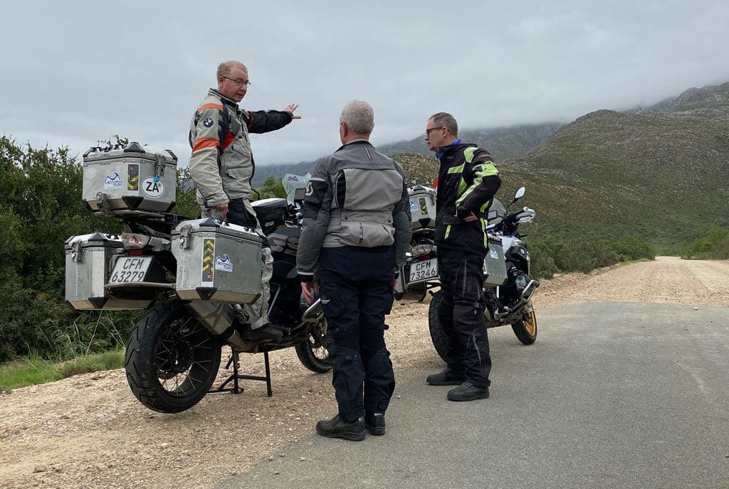 The group are parked at the side of a road and sorting directions.