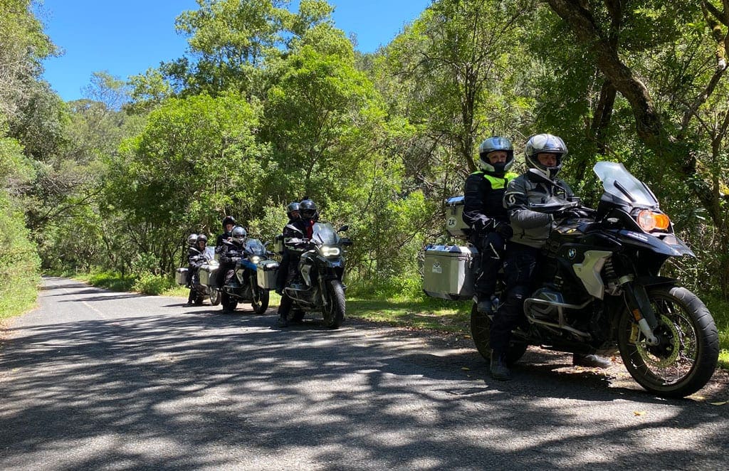 All the way 2 The group sit in pairs on their bikes as they ride along a forest road.