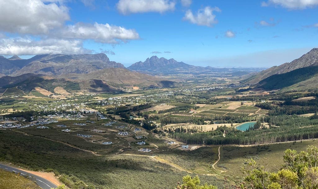 A scenic view of a town amongst mountains. 