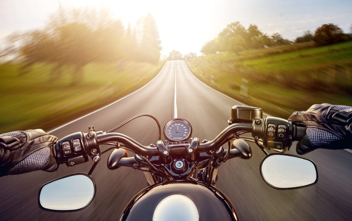 Hands of motorcyclist while riding motorcycle on a street